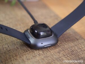 Fitbit attached to its charging adapter