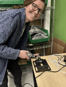 Woman in electronics lab is creating defects on a pin array connector.